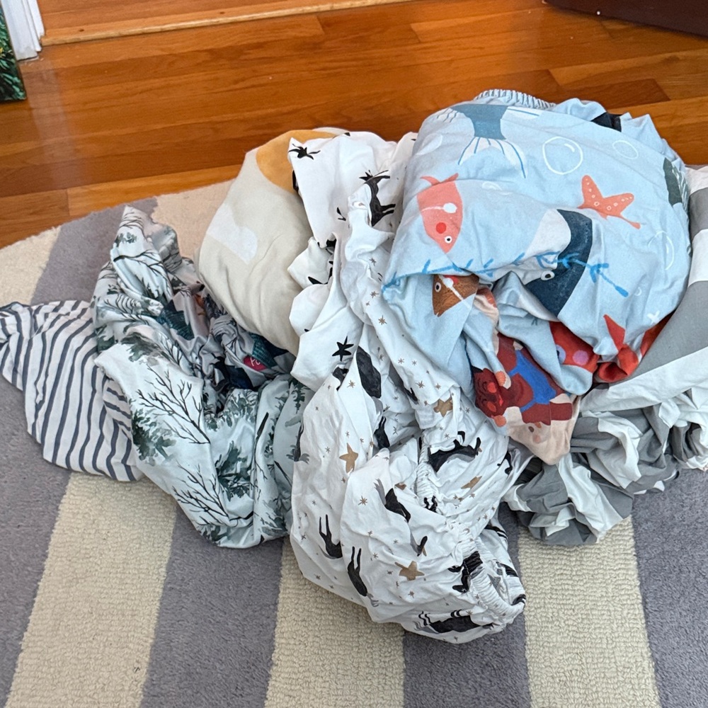 Pile of 9 toddler / crib sheets